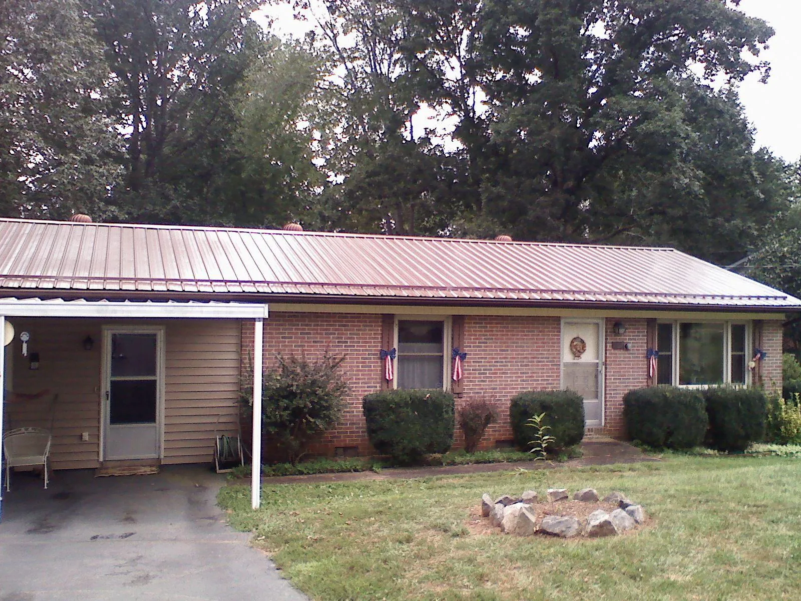 Bronze metal roof and carport on a brick ranch home — Roof Repair work by our crew in Magnolia